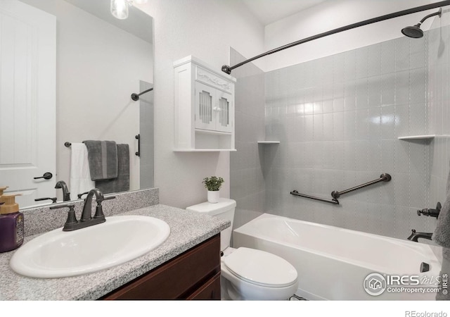 full bathroom featuring toilet, tiled shower / bath combo, and vanity