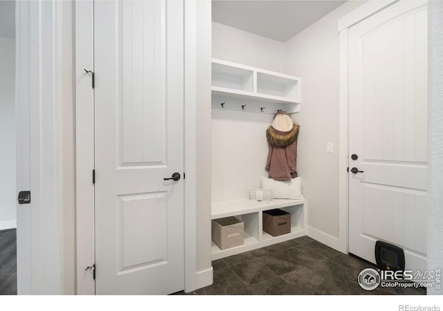 mudroom with dark tile patterned floors