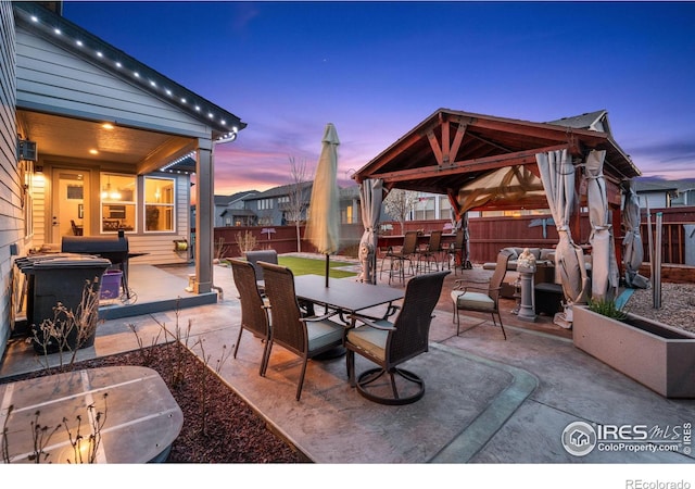 patio terrace at dusk featuring a gazebo