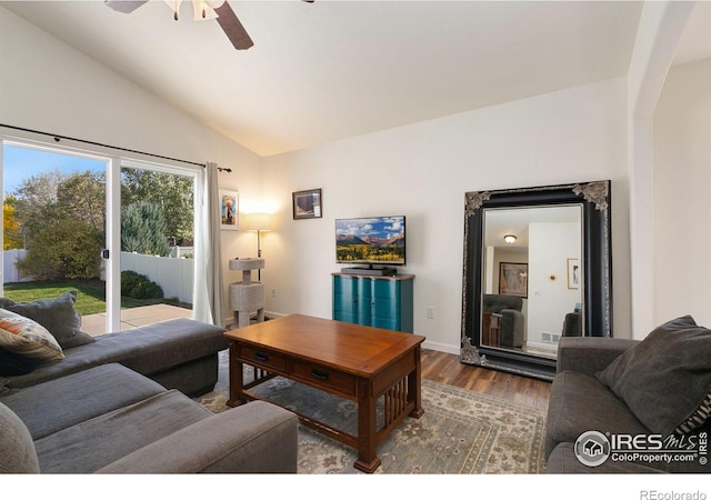 living room with ceiling fan, wood-type flooring, and vaulted ceiling