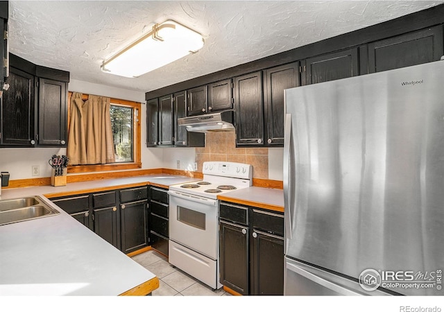 kitchen with white electric range, stainless steel refrigerator, light tile patterned floors, sink, and backsplash