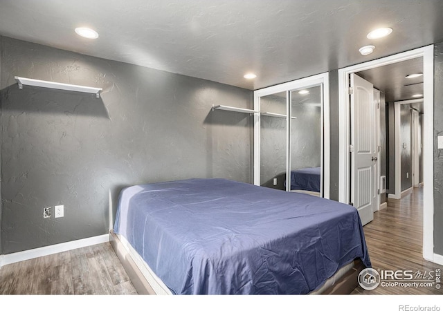 bedroom with hardwood / wood-style floors and a closet