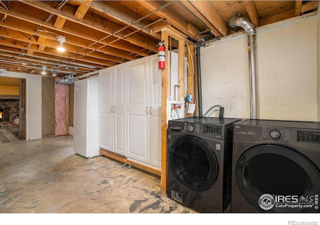 laundry area featuring washer and clothes dryer and cabinets