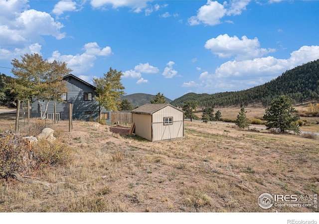 view of yard with a mountain view and a storage shed