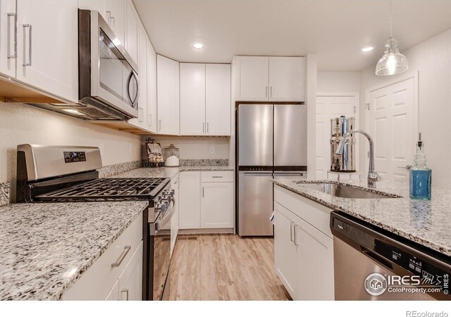 kitchen with white cabinetry, light hardwood / wood-style flooring, stainless steel appliances, and sink