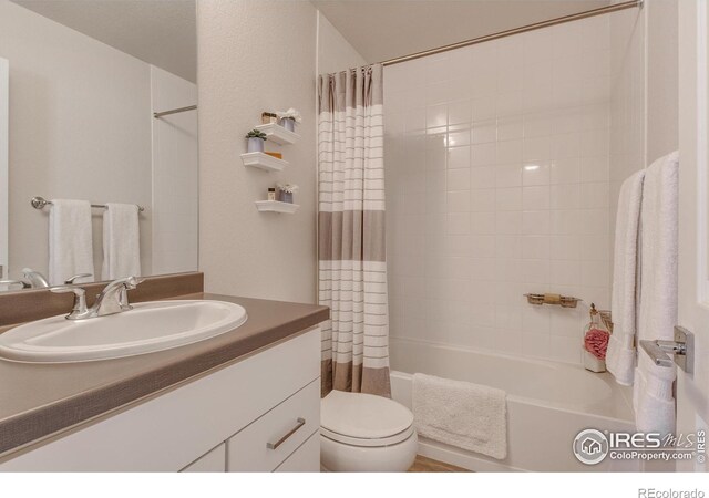 full bathroom with vanity, shower / bath combo, and toilet