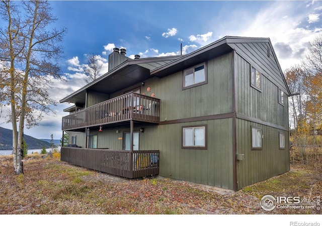 back of property with a deck with mountain view