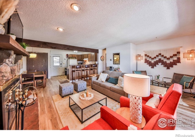 living room featuring light hardwood / wood-style flooring and a textured ceiling