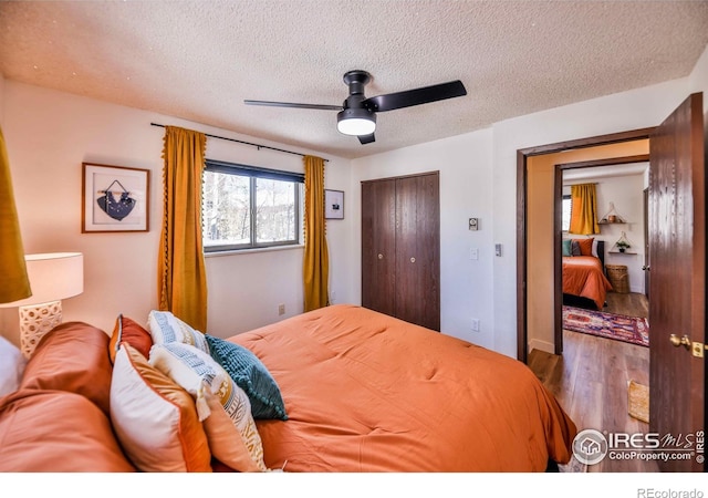 bedroom featuring a closet, ceiling fan, a textured ceiling, and dark hardwood / wood-style flooring