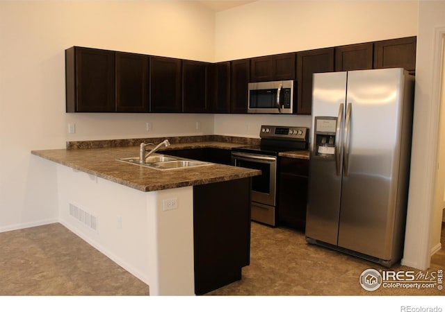 kitchen featuring sink, appliances with stainless steel finishes, kitchen peninsula, and dark brown cabinets