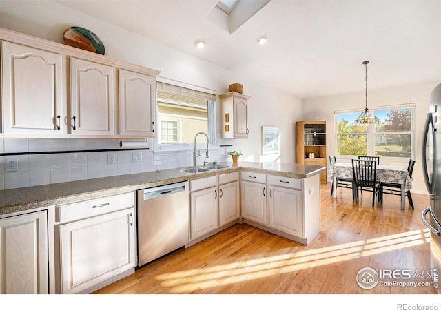 kitchen with sink, light hardwood / wood-style flooring, stainless steel appliances, and a healthy amount of sunlight