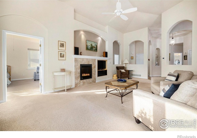 living room with light carpet, vaulted ceiling, a fireplace, and ceiling fan