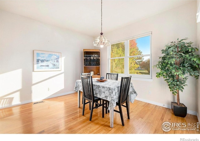 dining space featuring an inviting chandelier and light wood-type flooring