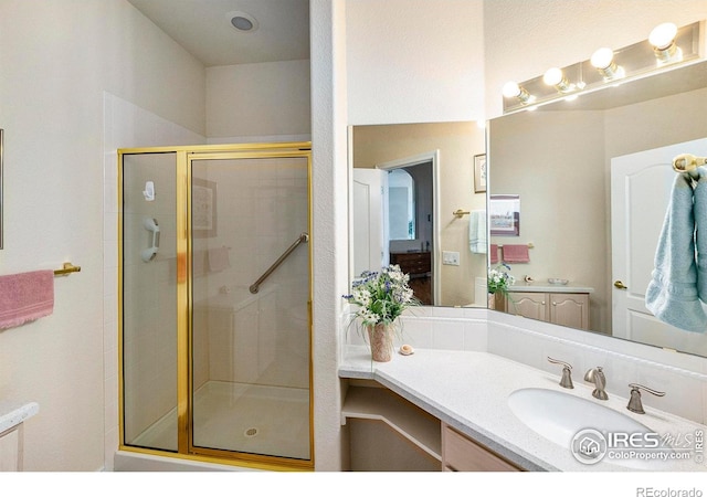 bathroom with vanity and a shower with door