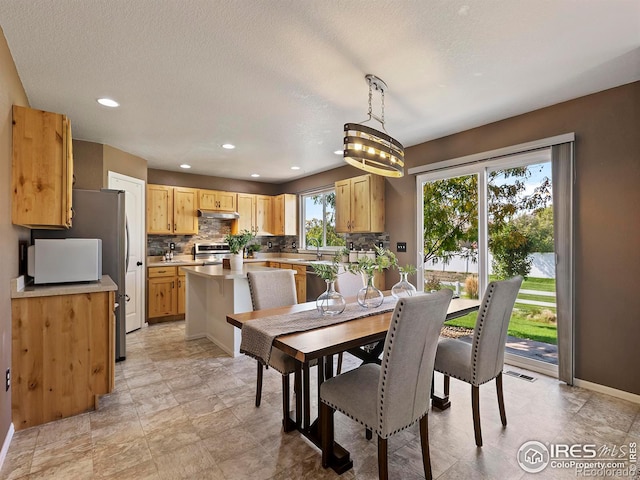 dining area featuring a notable chandelier, a textured ceiling, and sink