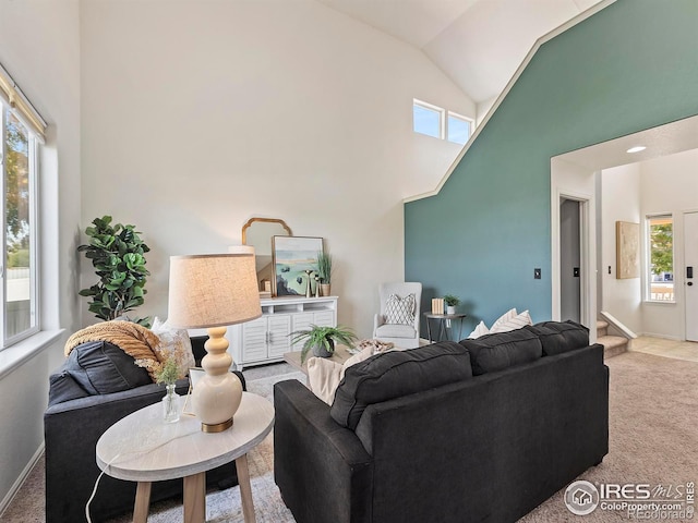 living room with carpet and high vaulted ceiling