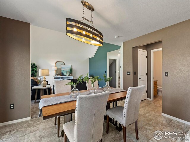 dining area with an inviting chandelier and a textured ceiling