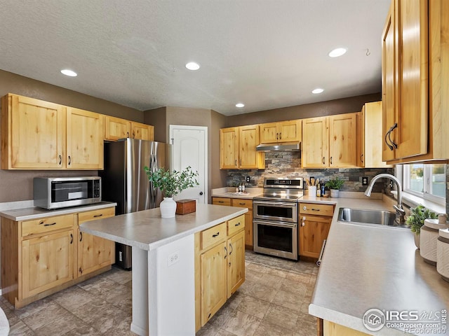 kitchen featuring light brown cabinetry, sink, appliances with stainless steel finishes, and a center island