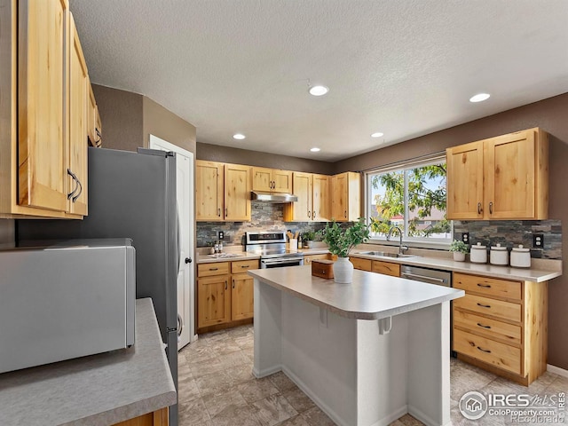 kitchen with sink, a kitchen island, stainless steel appliances, decorative backsplash, and light brown cabinets