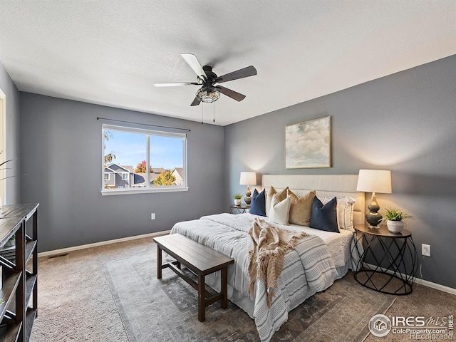 bedroom with a textured ceiling, carpet floors, and ceiling fan