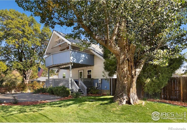 front facade with a wooden deck and a front lawn