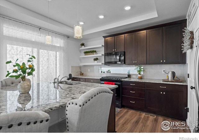 kitchen with tasteful backsplash, light stone countertops, black appliances, sink, and dark hardwood / wood-style floors