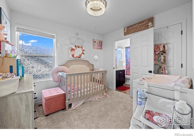 bedroom featuring light carpet, ensuite bathroom, and a nursery area