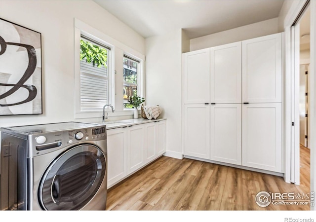 washroom with sink, washer / clothes dryer, light hardwood / wood-style flooring, and cabinets