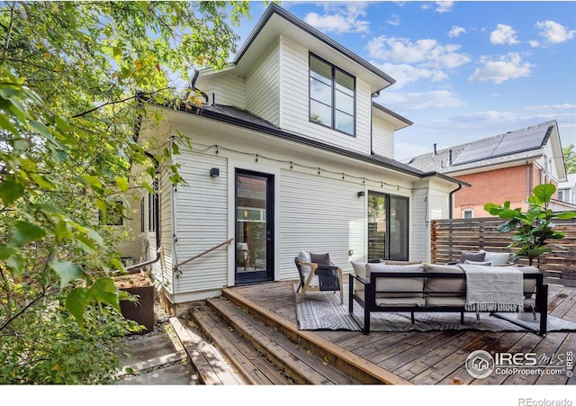 back of property featuring a deck and outdoor lounge area