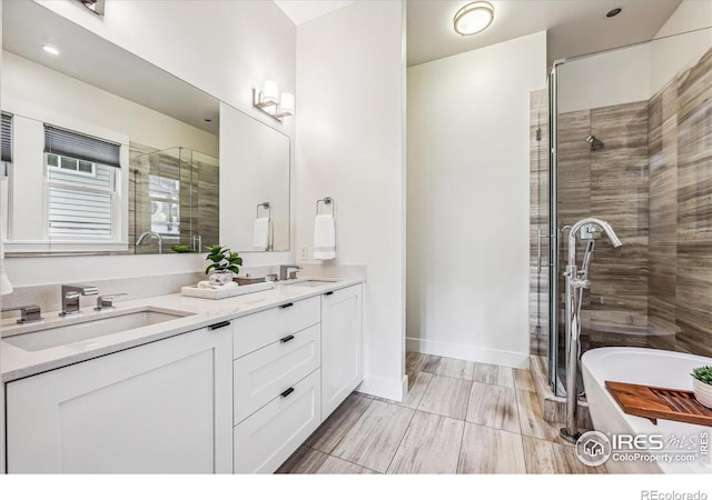 bathroom with vanity and shower with separate bathtub