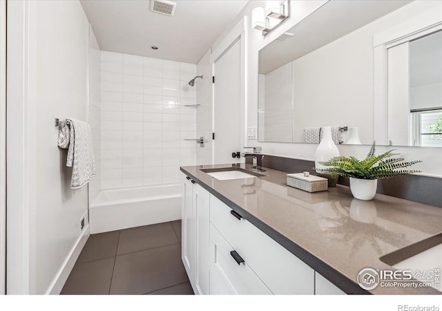 bathroom with tiled shower / bath, vanity, and tile patterned floors