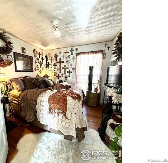 bedroom with hardwood / wood-style flooring, a textured ceiling, and crown molding