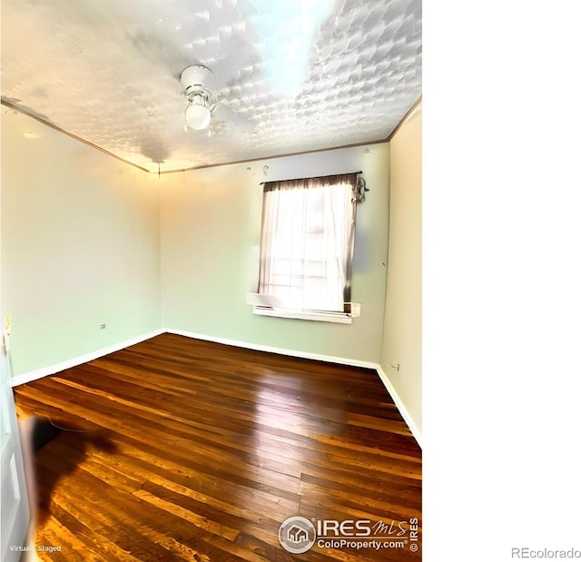 unfurnished room with wood-type flooring and baseboards