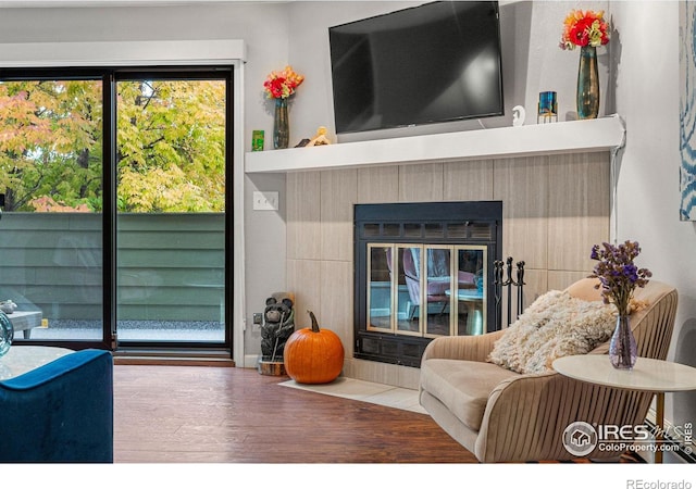 living room featuring a glass covered fireplace and wood finished floors