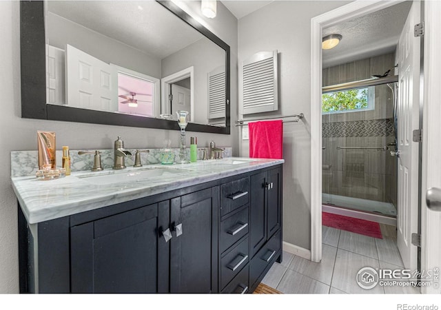 bathroom with vanity, an enclosed shower, a textured ceiling, and tile patterned flooring