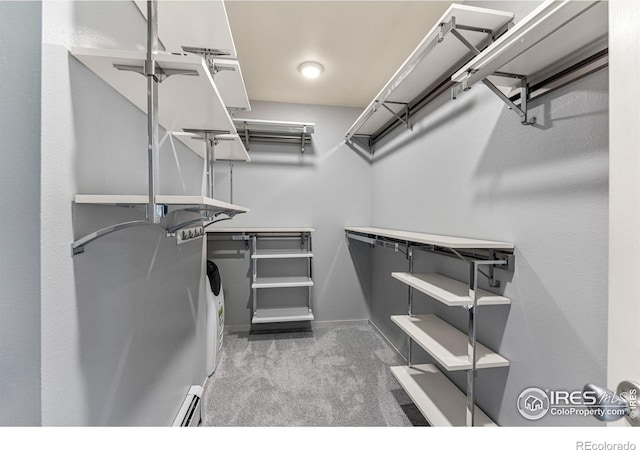 walk in closet featuring a baseboard radiator and dark carpet