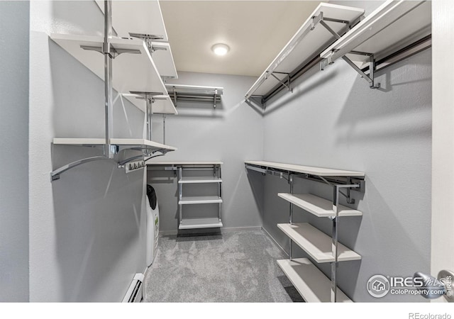 spacious closet featuring baseboard heating and carpet floors