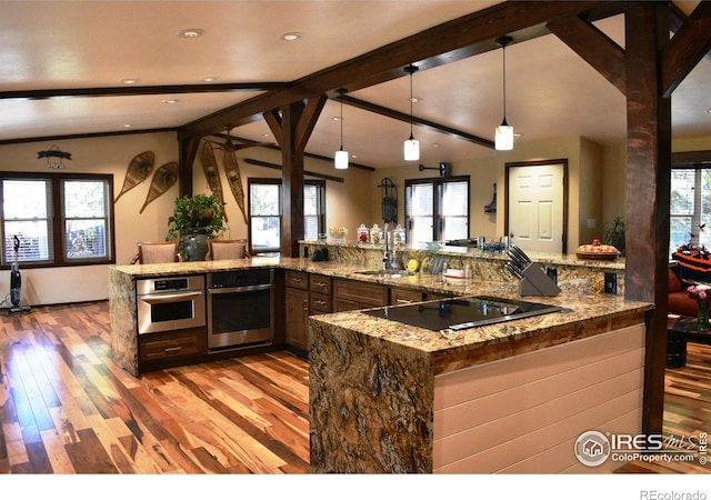 kitchen featuring stainless steel oven, pendant lighting, light hardwood / wood-style floors, and black electric cooktop