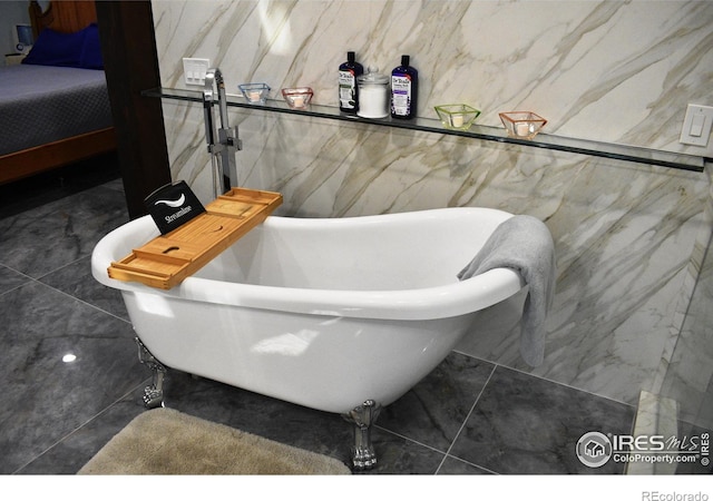 bathroom with a tub and tile walls