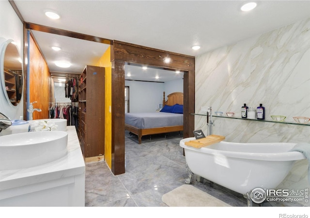 bathroom featuring vanity, tile walls, and a washtub