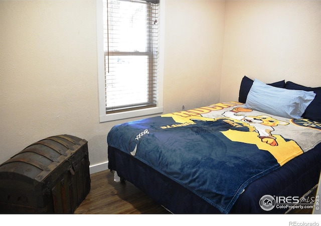 bedroom with dark wood-type flooring