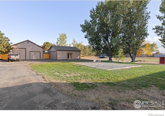 exterior space featuring a front lawn, an outbuilding, and a garage