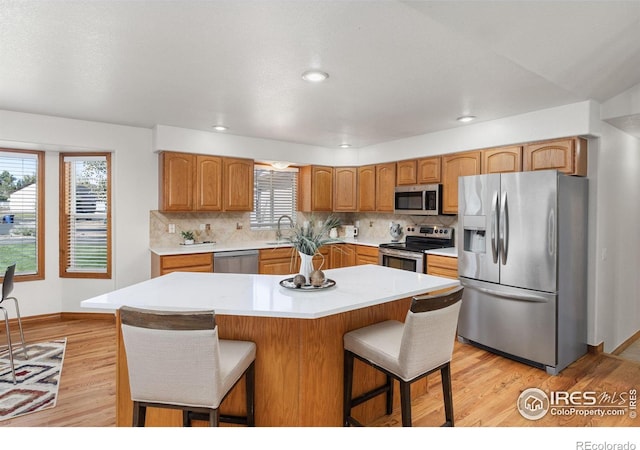 kitchen featuring light hardwood / wood-style floors, a breakfast bar, stainless steel appliances, and a kitchen island