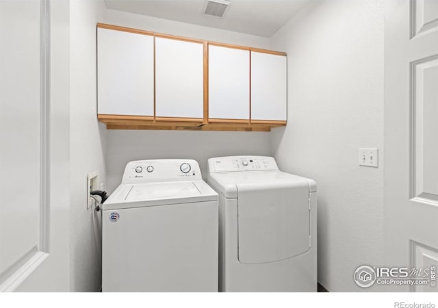 laundry area featuring independent washer and dryer and cabinets