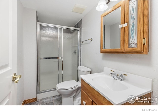 bathroom with a shower with door, vanity, and toilet