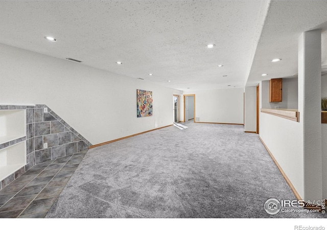 interior space with a textured ceiling and carpet flooring