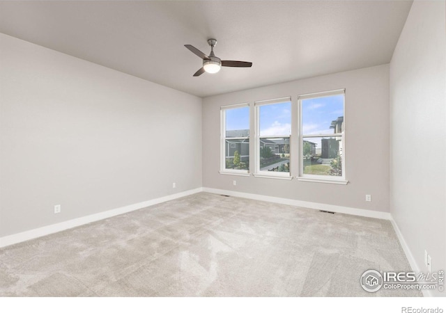 carpeted spare room with ceiling fan