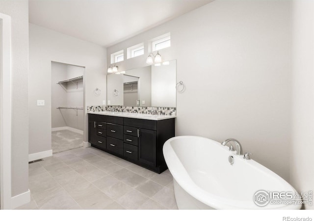 bathroom featuring vanity, a tub to relax in, and tile patterned flooring