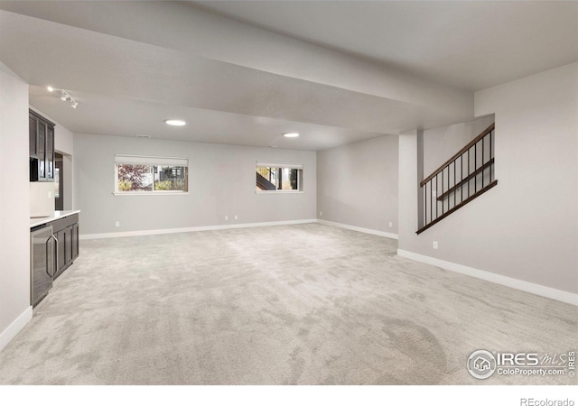 unfurnished living room featuring light carpet