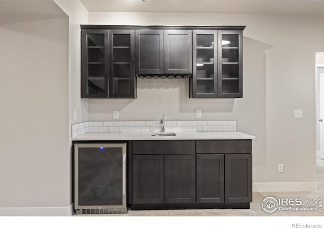 bar featuring light colored carpet, wine cooler, and sink